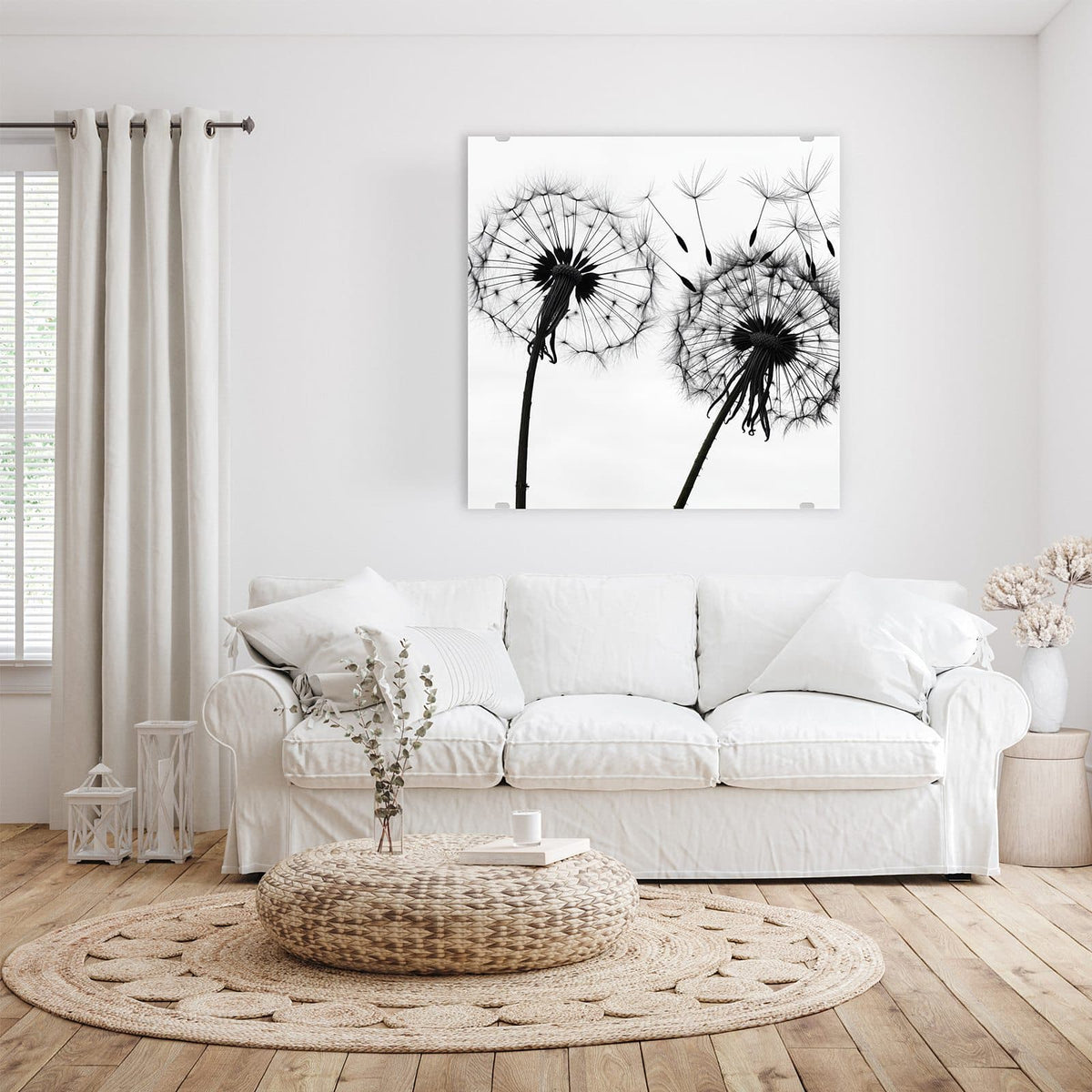 Glasbild Pusteblumen in Grau an der Wand – weiße Pusteblumen in Schwarz-Weiß, zwei Samenstände, Samen fliegen nach rechts weg