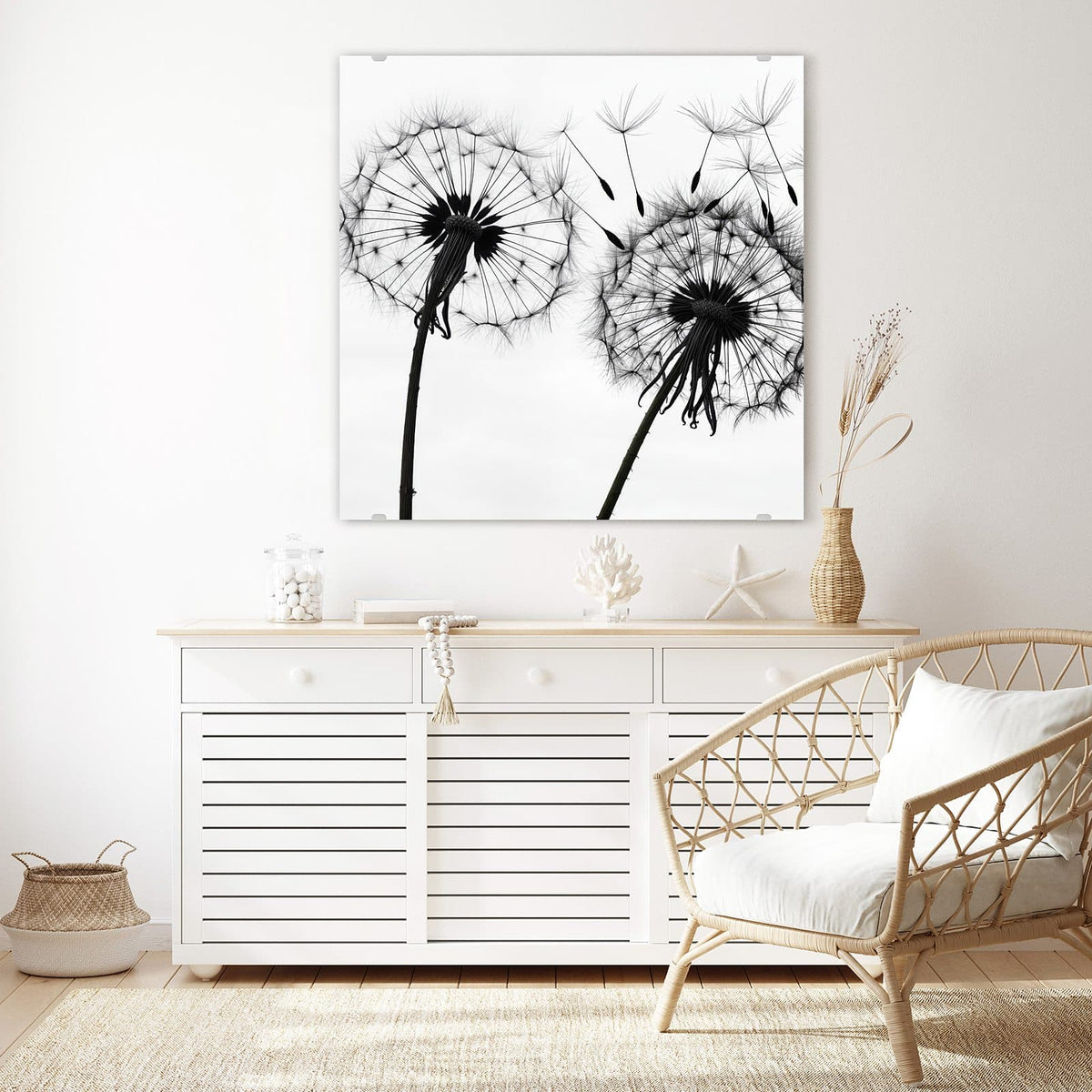 Glasbild Pusteblumen in Grau an der Wand – weiße Pusteblumen in Schwarz-Weiß, zwei Samenstände, Samen fliegen nach rechts weg