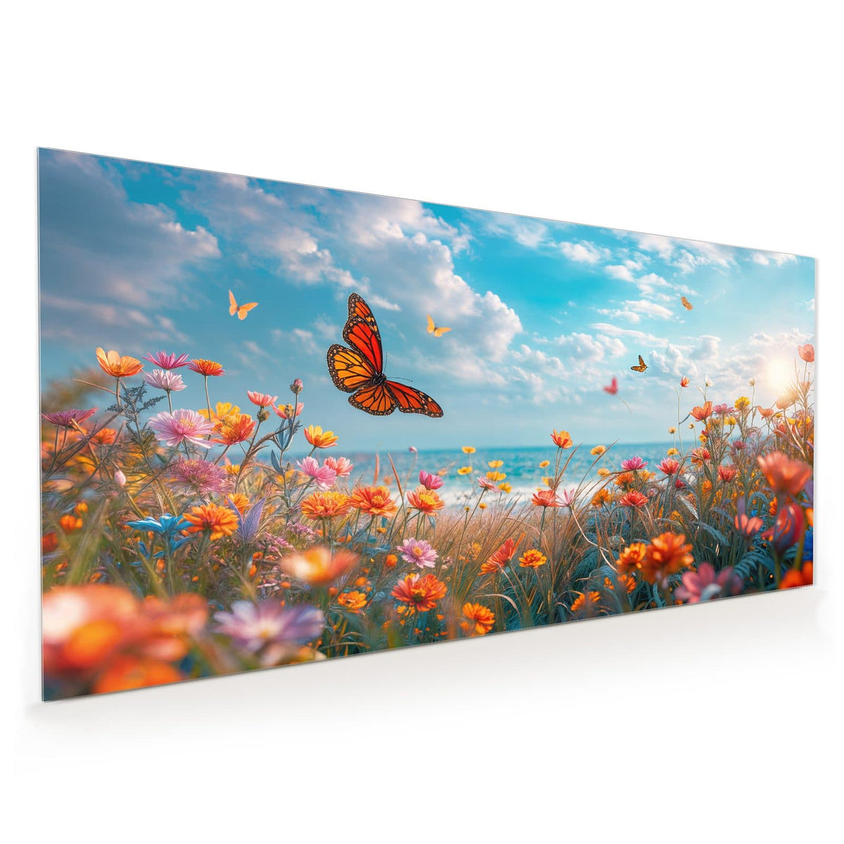 Küchenrückwand aus Glas im Hochformat mit Motiv Blütenwiese am Meer: Bunte Blumenwiese am Meer mit Monarchfalter, dahinter türkises Wasser und Wolkenhimmel