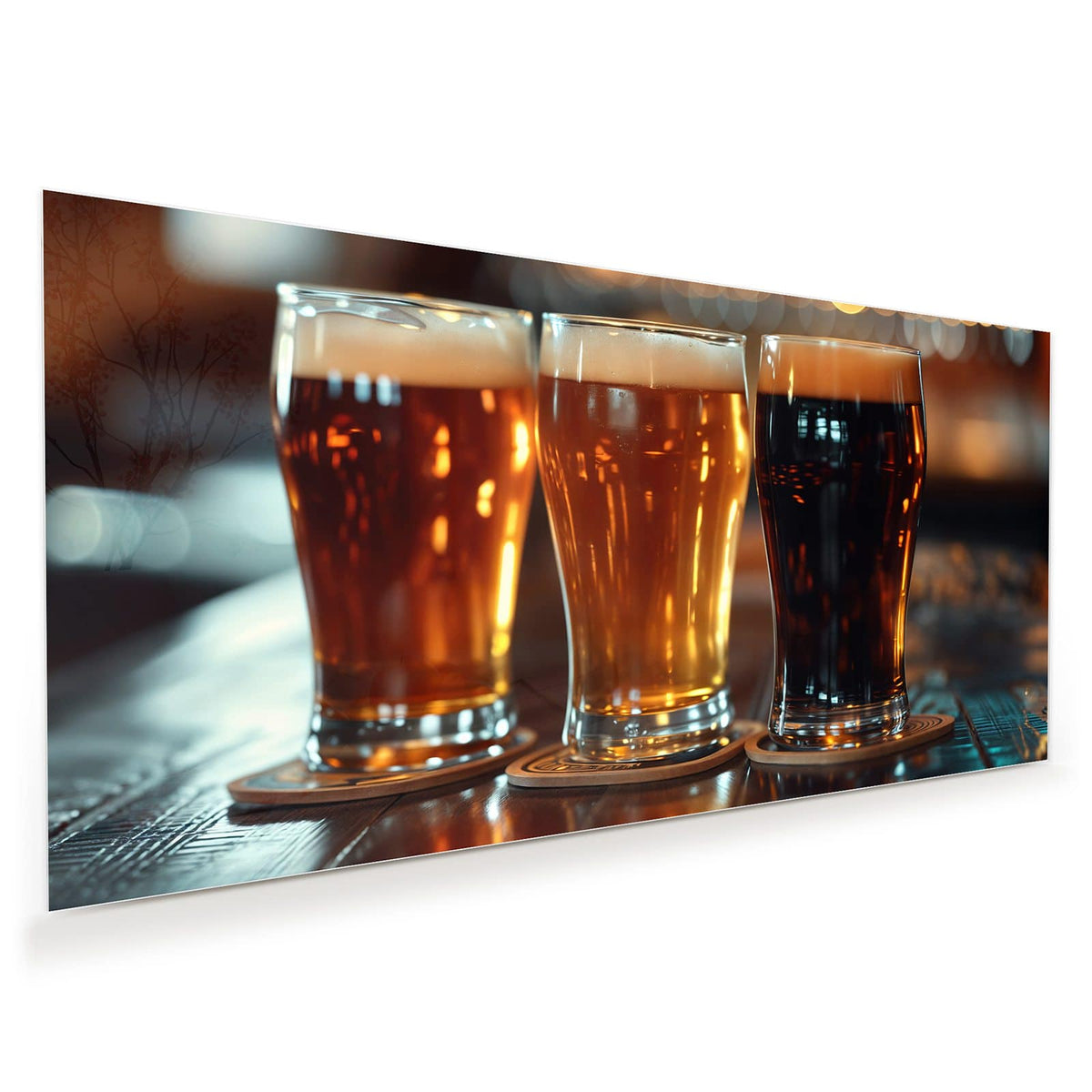 Drei Gläser mit hellem, bernsteinfarbenem und dunklem Bier auf Untersetzern, dahinter warme Lichtpunkte.