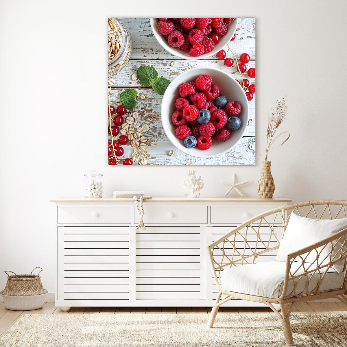 Glasbild Beeren und Haferflocken an der Wand – Zwei weiße Schalen mit Himbeeren, Blaubeeren und Johannisbeeren, dazu Haferflocken und Minze auf weißem Holz