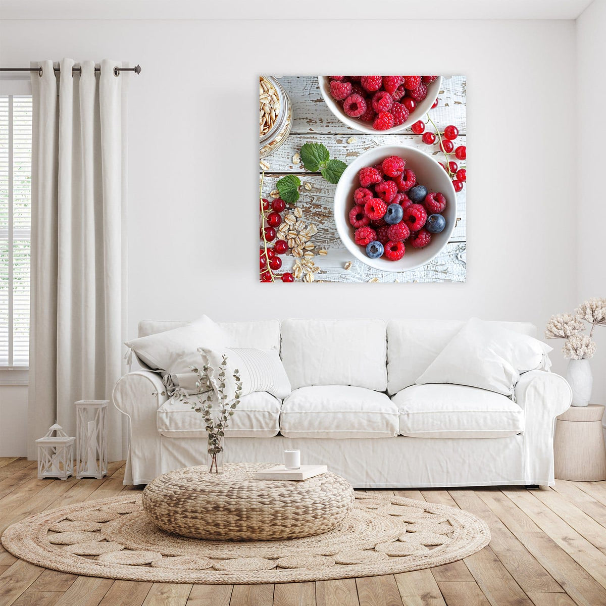 Zwei weiße Schalen mit Himbeeren, Blaubeeren und Johannisbeeren, dazu Haferflocken und Minze auf weißem Holz