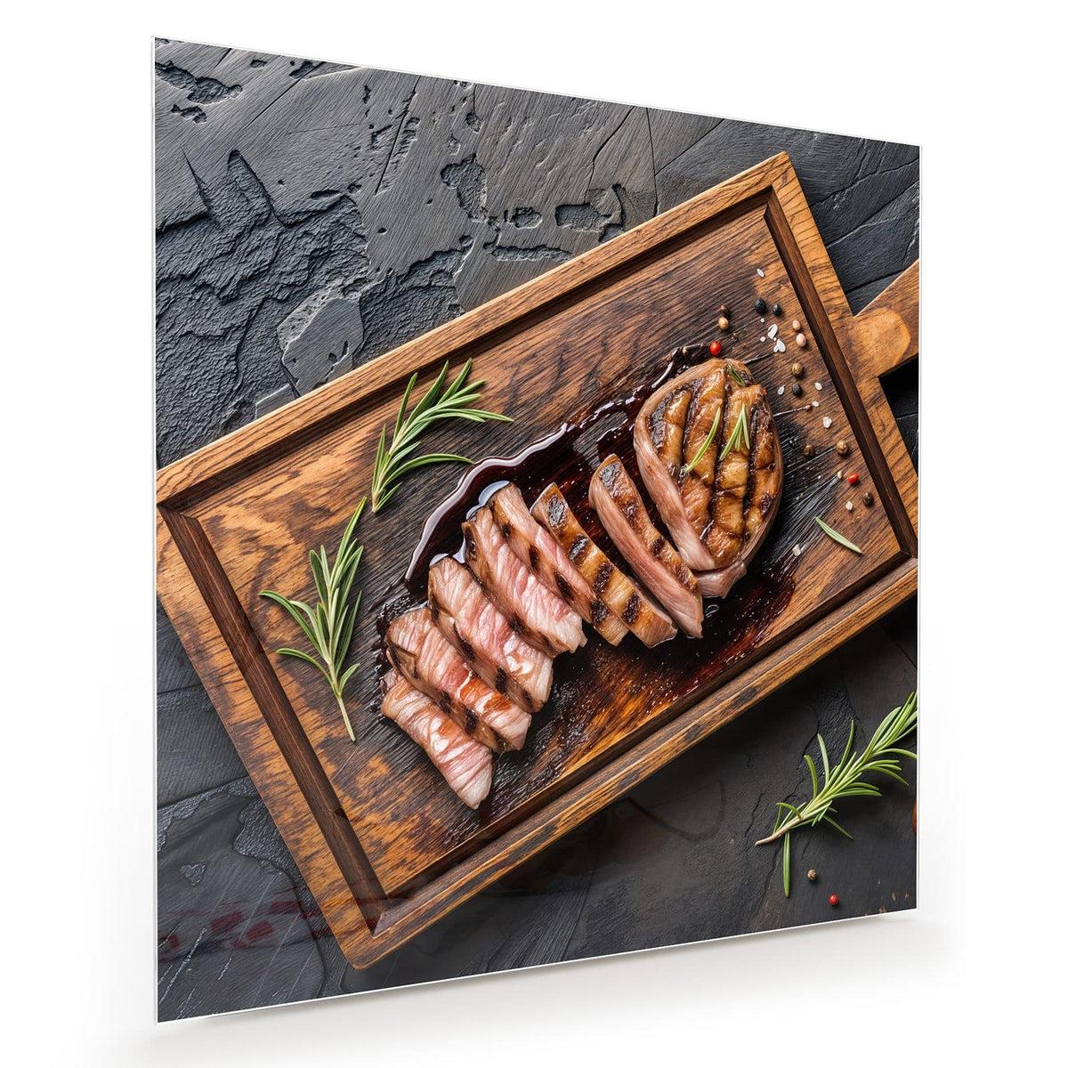 Rosa gebratenes Steak in Scheiben aufgefächert auf dunklem Holzbrett, Rosmarin und Pfeffer auf Schiefer.