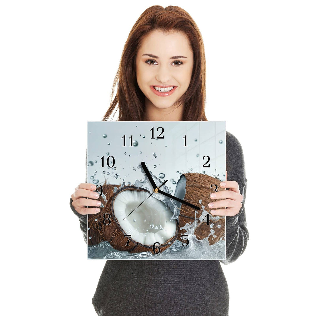 Quadratische Wanduhr aus Glas Halbe Kokosnuss in zwei Händen gehalten – Größenvergleich, 30 × 30 cm