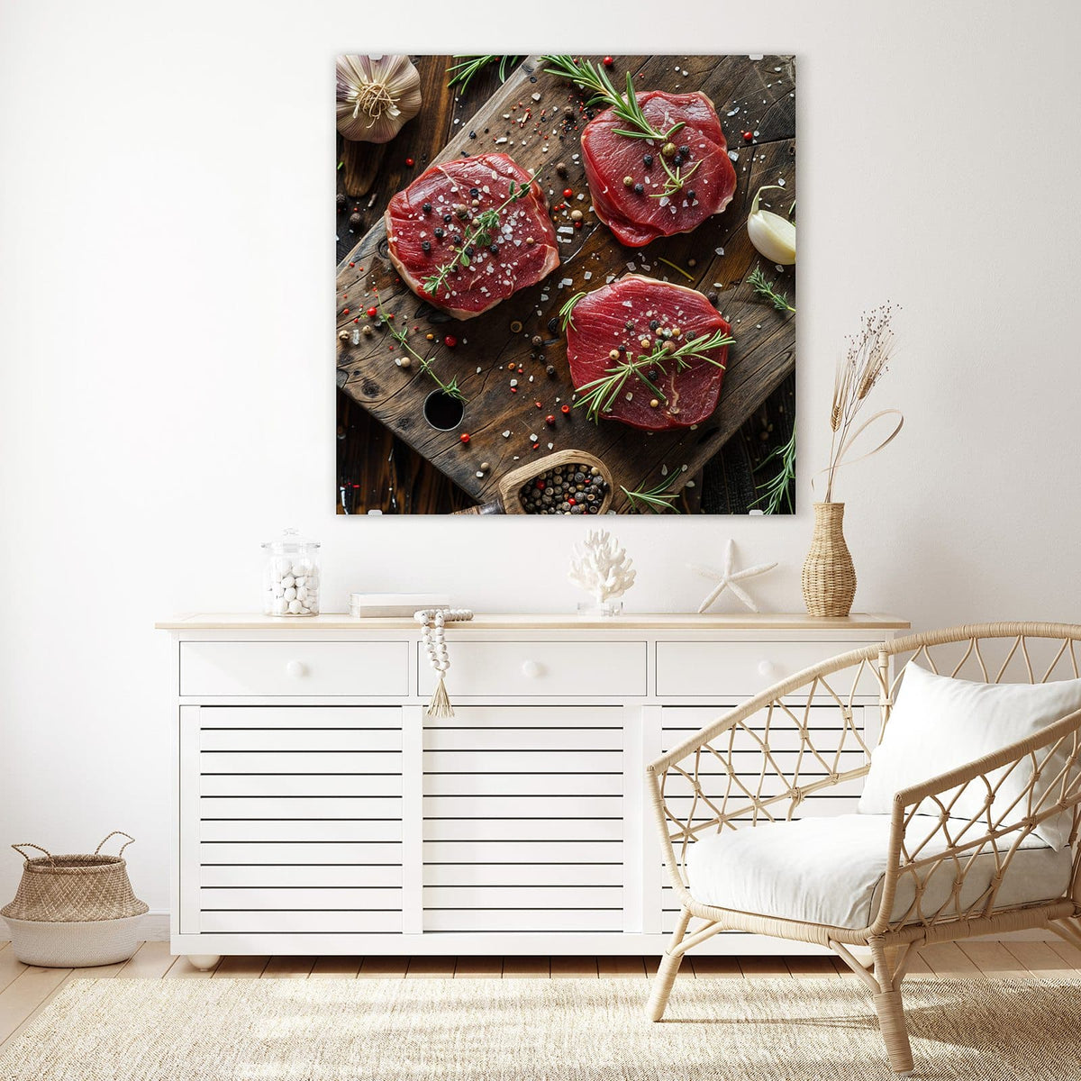 Glasbild Steaks mit Knoblauch an der Wand – Drei rohe Rindersteaks auf Holzbrett mit Rosmarin, Knoblauch, Salz und Pfefferkörnern