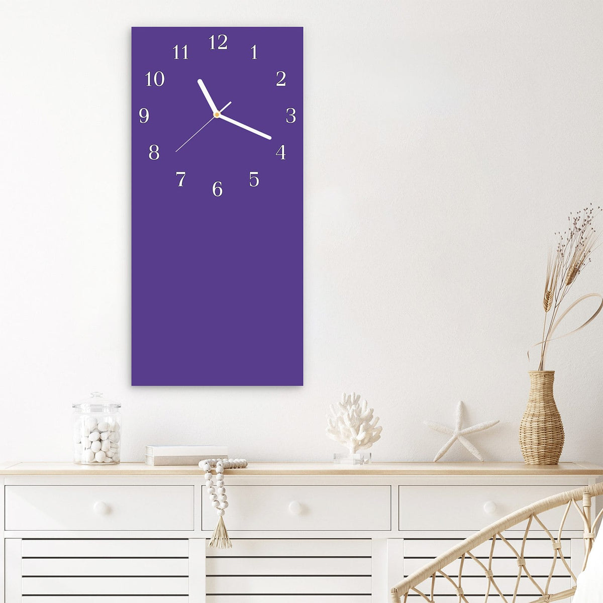 Wanduhr aus Glas im Hochformat Amethyst mit Ziffernblatt Klassisch über einem weißen Sideboard