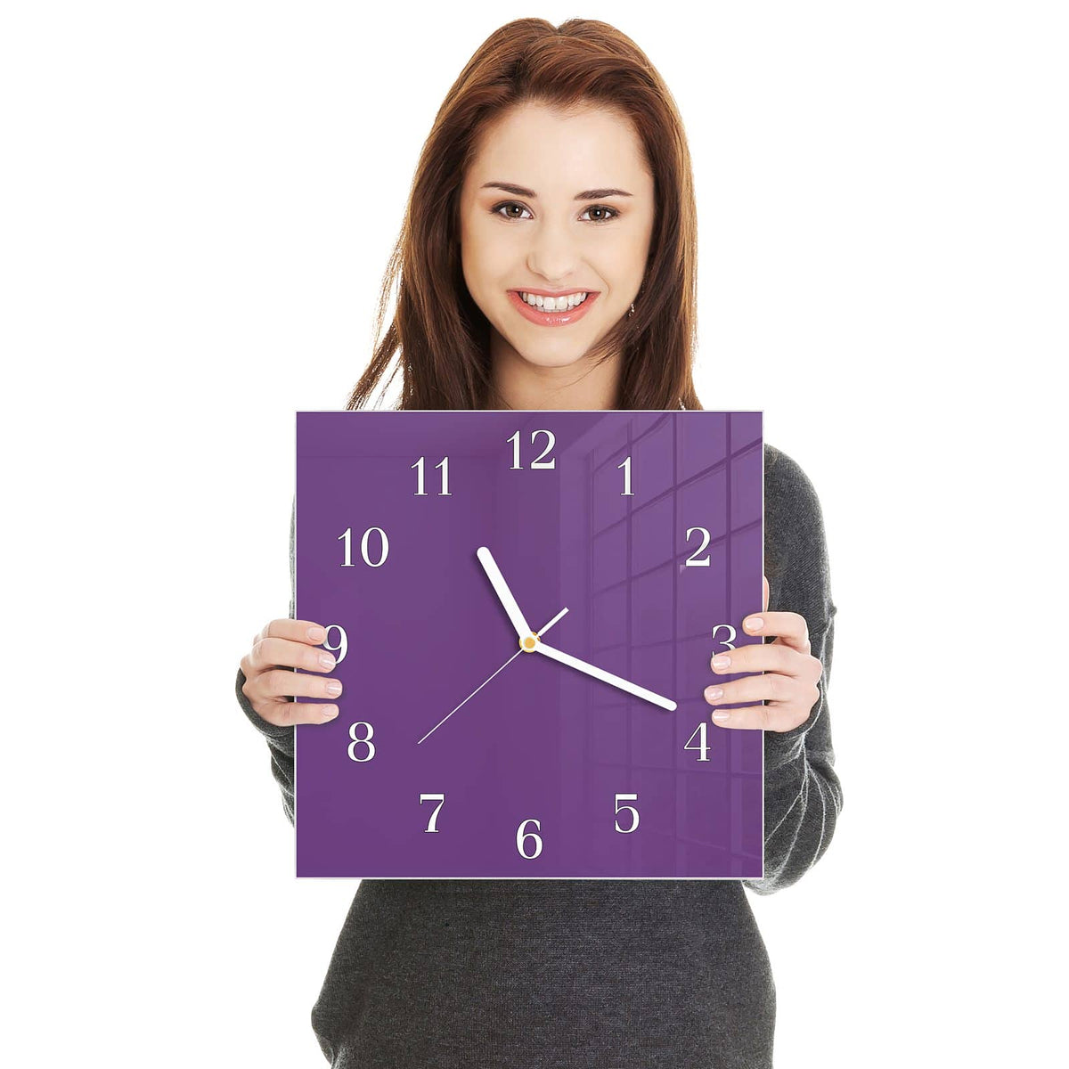 Quadratische Wanduhr aus Glas Pflaumenlila in zwei Händen gehalten – Größenvergleich, 30 × 30 cm