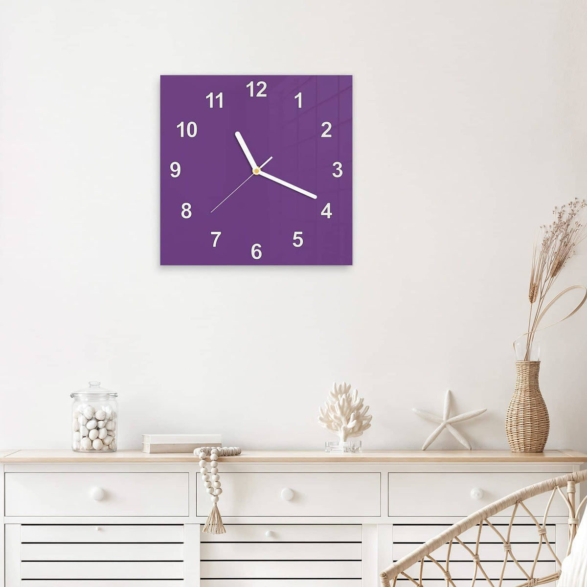 Quadratische Wanduhr aus Glas Pflaumenlila mit Ziffernblatt Modern über einem weißen Sideboard