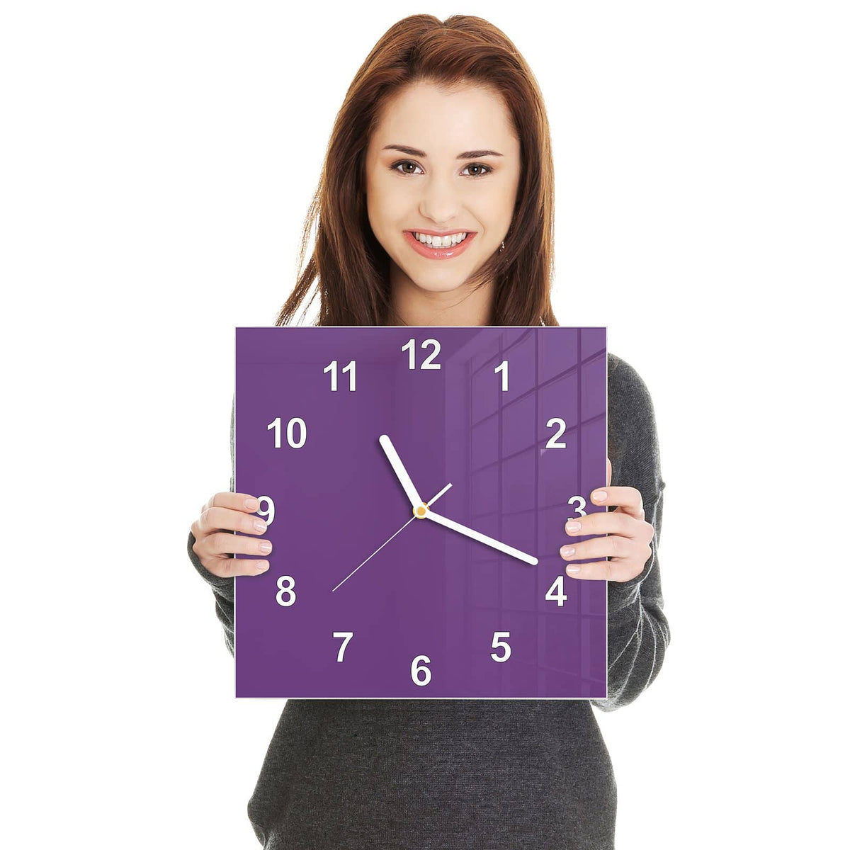 Quadratische Wanduhr aus Glas Pflaumenlila in zwei Händen gehalten – Größenvergleich, 30 × 30 cm