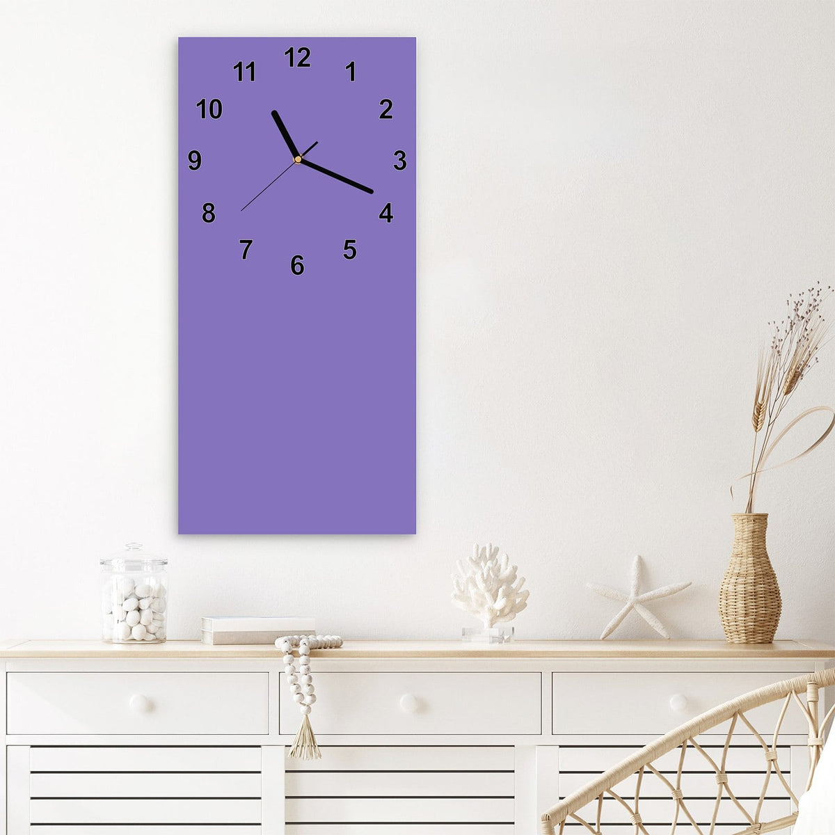Wanduhr aus Glas im Hochformat Lavendelviolett mit Ziffernblatt Modern über einem weißen Sideboard