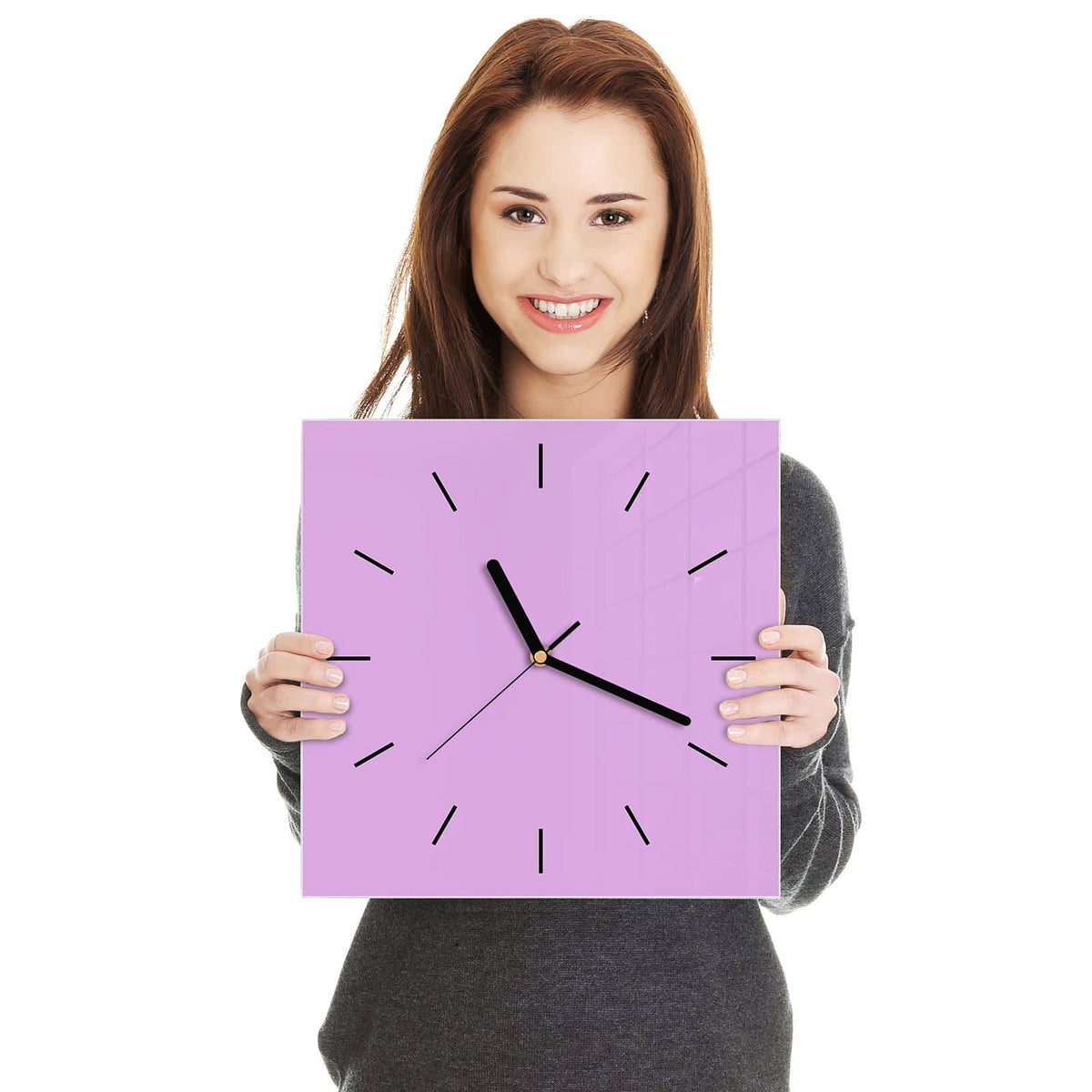 Quadratische Wanduhr aus Glas Fliederlila in zwei Händen gehalten – Größenvergleich, 30 × 30 cm