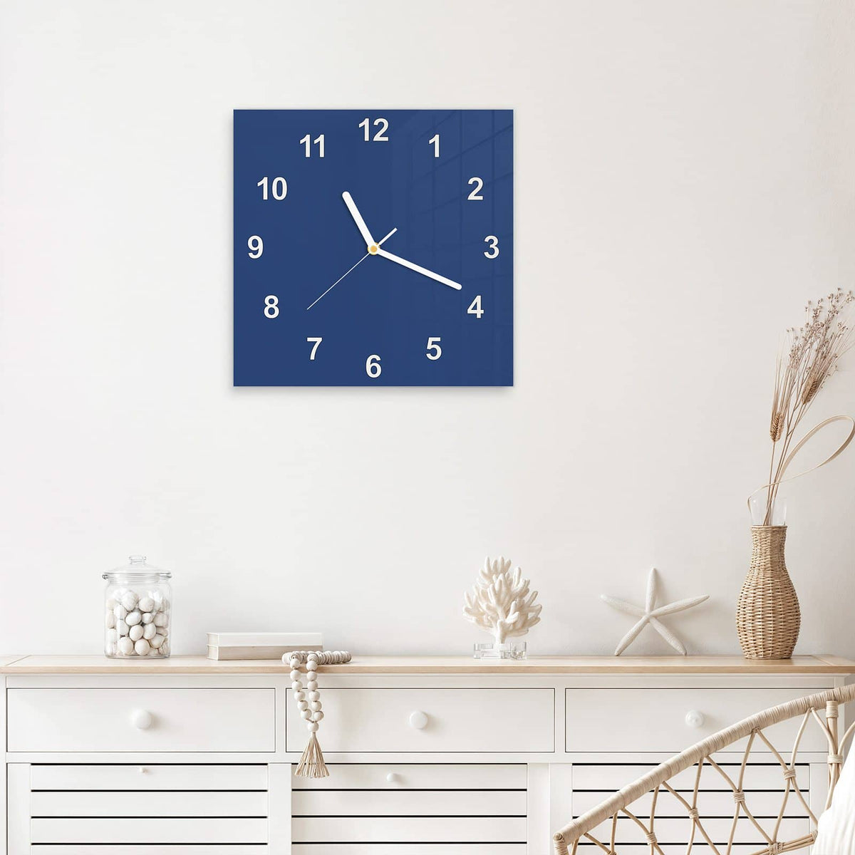 Quadratische Wanduhr aus Glas Jeansblau mit Ziffernblatt Modern über einem weißen Sideboard