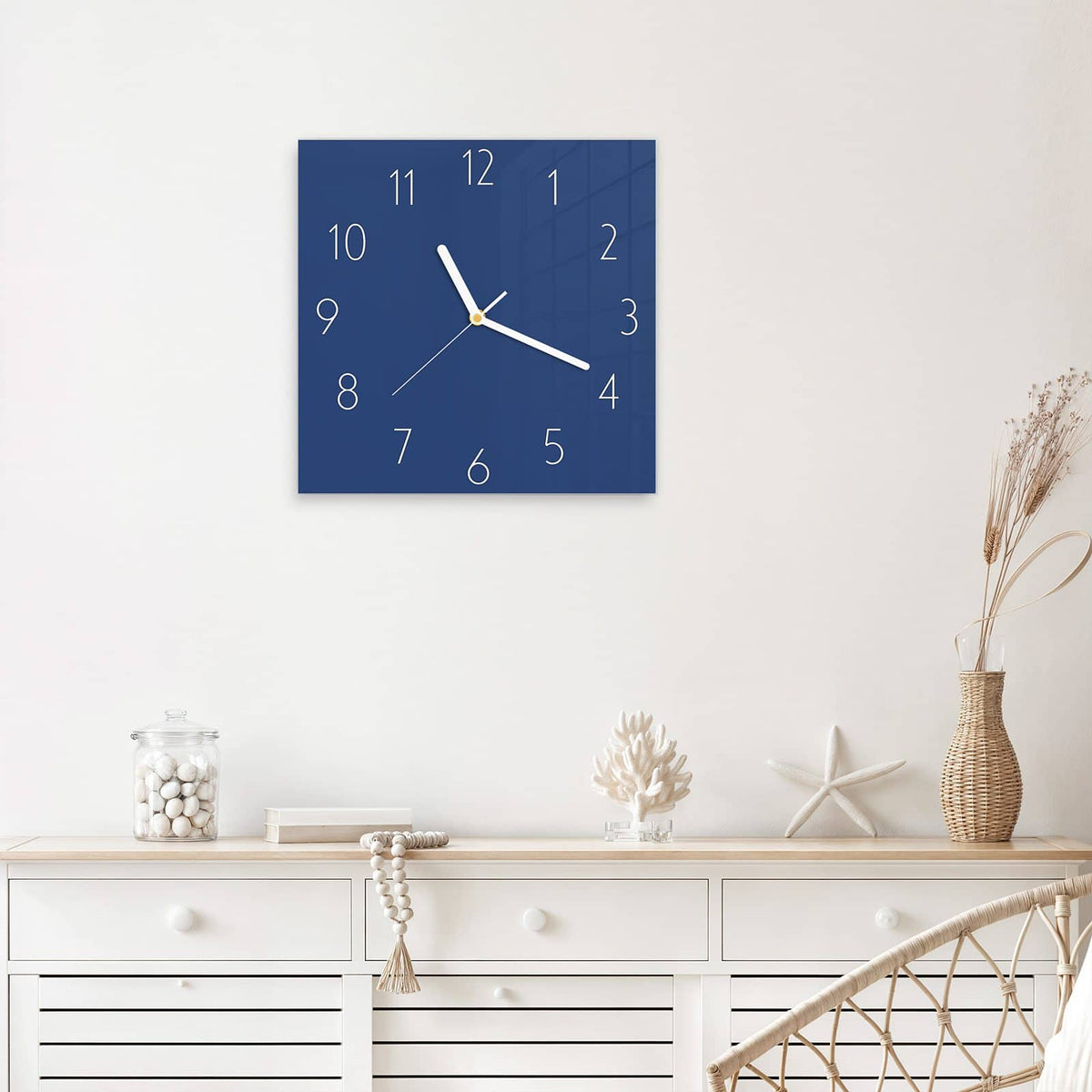 Quadratische Wanduhr aus Glas Jeansblau mit Ziffernblatt Elegant über einem weißen Sideboard