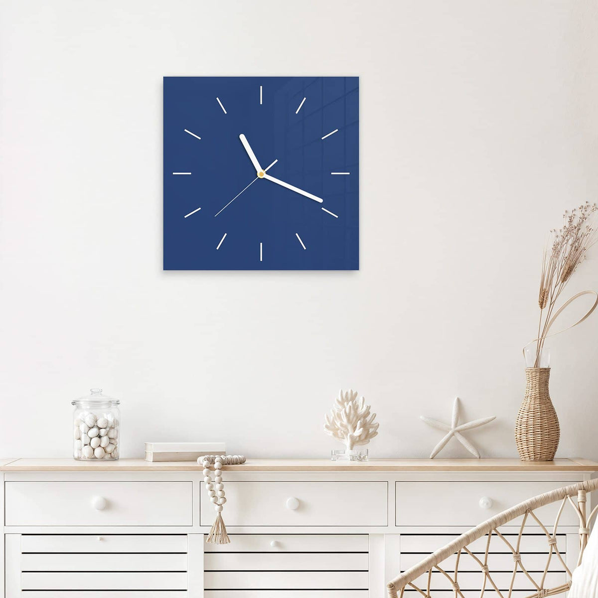 Quadratische Wanduhr aus Glas Jeansblau mit Ziffernblatt Linie über einem weißen Sideboard