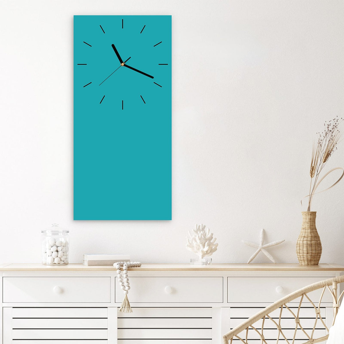 Wanduhr aus Glas im Hochformat Lagunentürkis mit Ziffernblatt Linie über einem weißen Sideboard