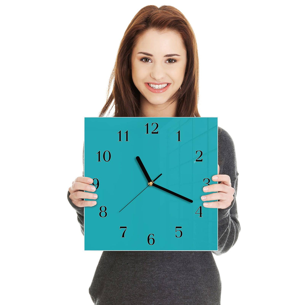 Quadratische Wanduhr aus Glas Lagunentürkis in zwei Händen gehalten – Größenvergleich, 30 × 30 cm