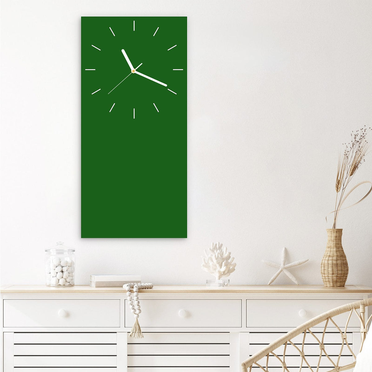 Wanduhr aus Glas im Hochformat Waldgrün mit Ziffernblatt Linie über einem weißen Sideboard