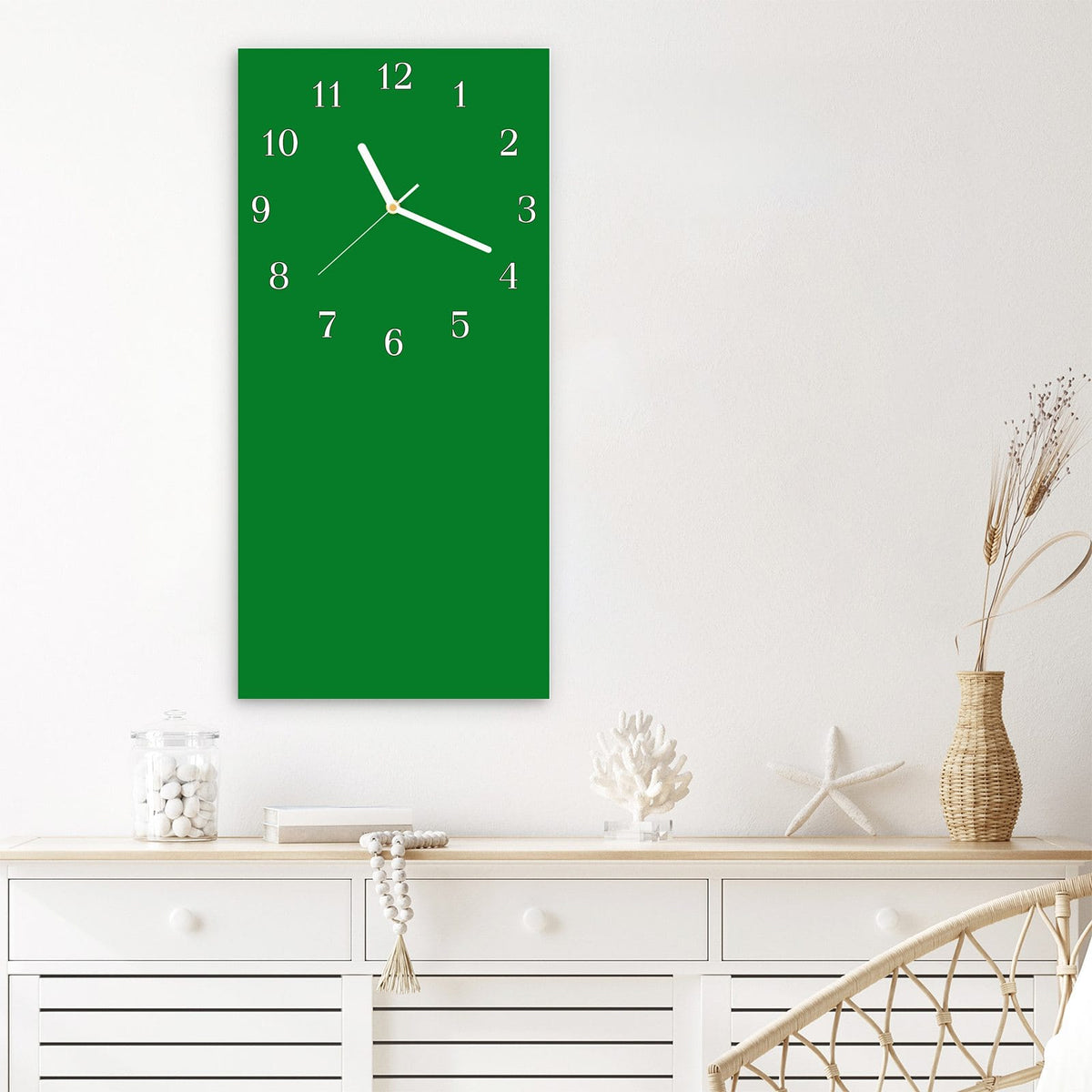 Wanduhr aus Glas im Hochformat Smaragdgrün mit Ziffernblatt Klassisch über einem weißen Sideboard