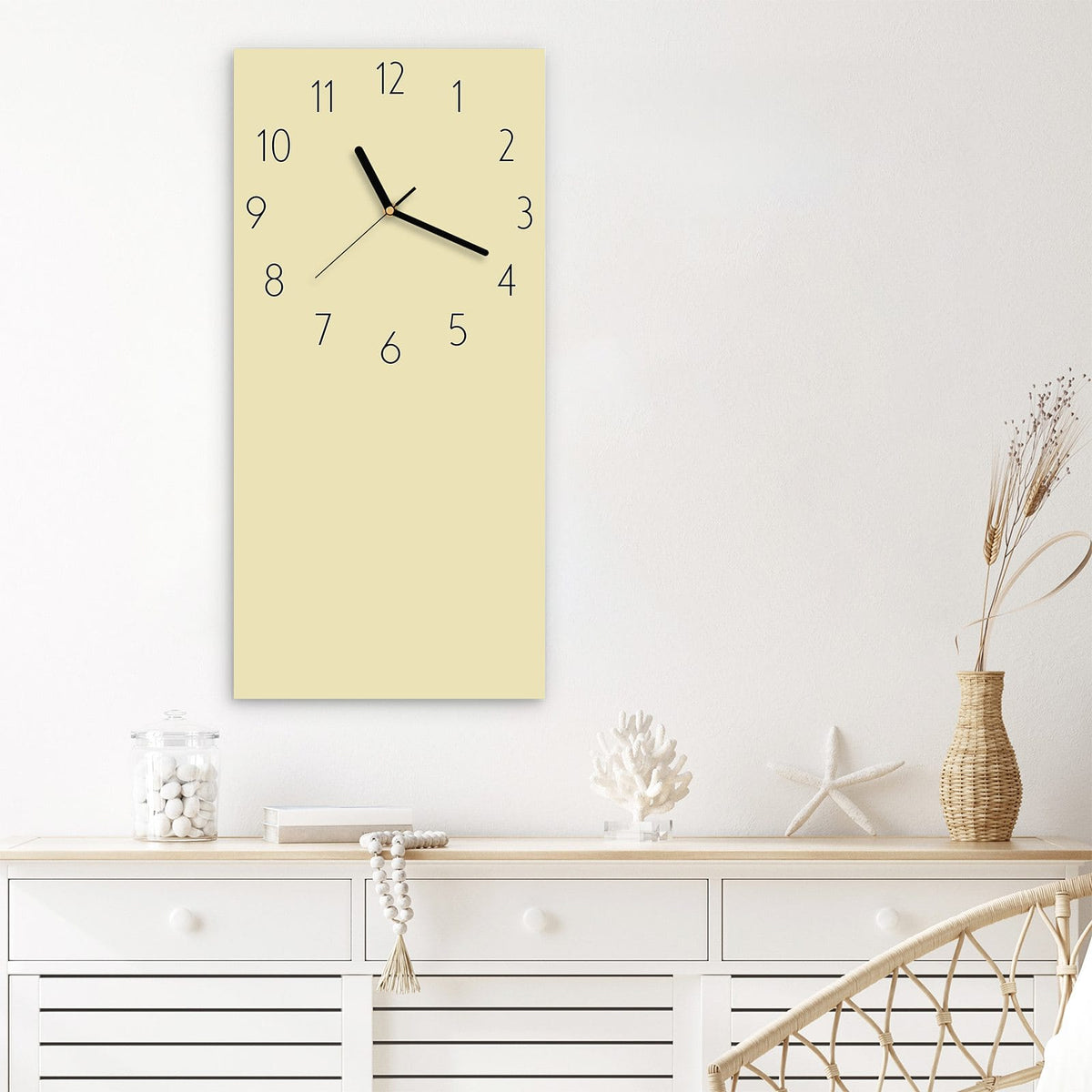 Wanduhr aus Glas im Hochformat Sandbeige mit Ziffernblatt Elegant über einem weißen Sideboard
