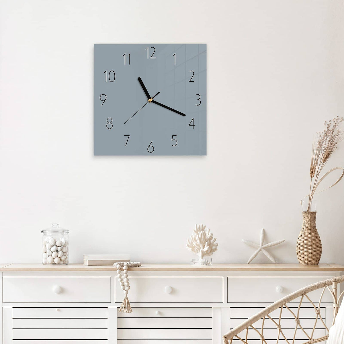 Quadratische Wanduhr aus Glas Schiefergrau mit Ziffernblatt Elegant über einem weißen Sideboard