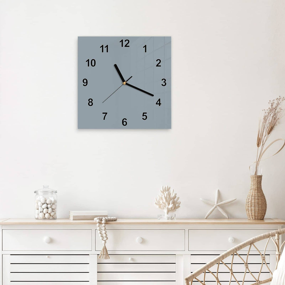 Quadratische Wanduhr aus Glas Schiefergrau mit Ziffernblatt Modern über einem weißen Sideboard